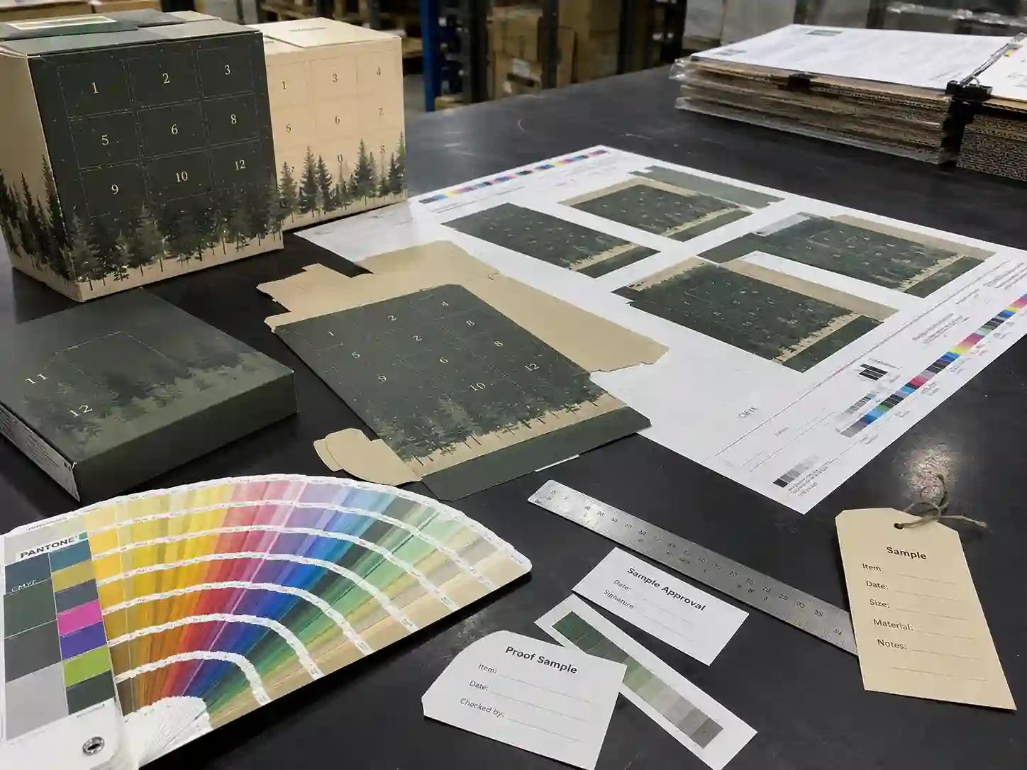 Printing proof table with Pantone cards and CMYK sheets for advent calendar box finishing options