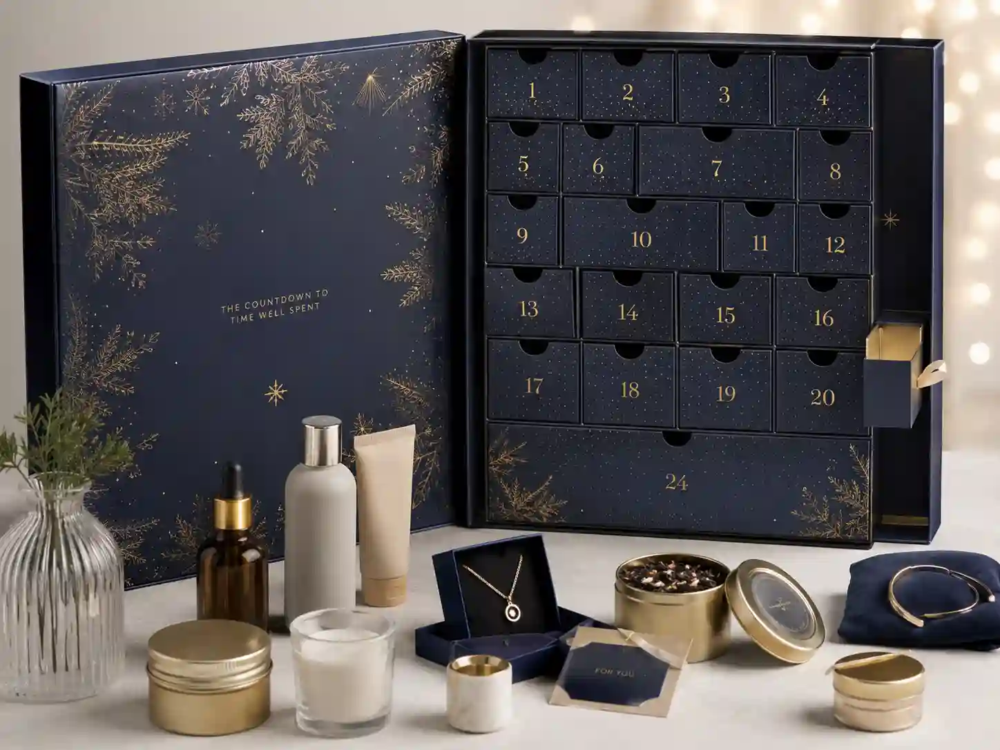 Premium advent calendar gift set retail presentation with cosmetic samples, candles, tea items, and custom paper inserts