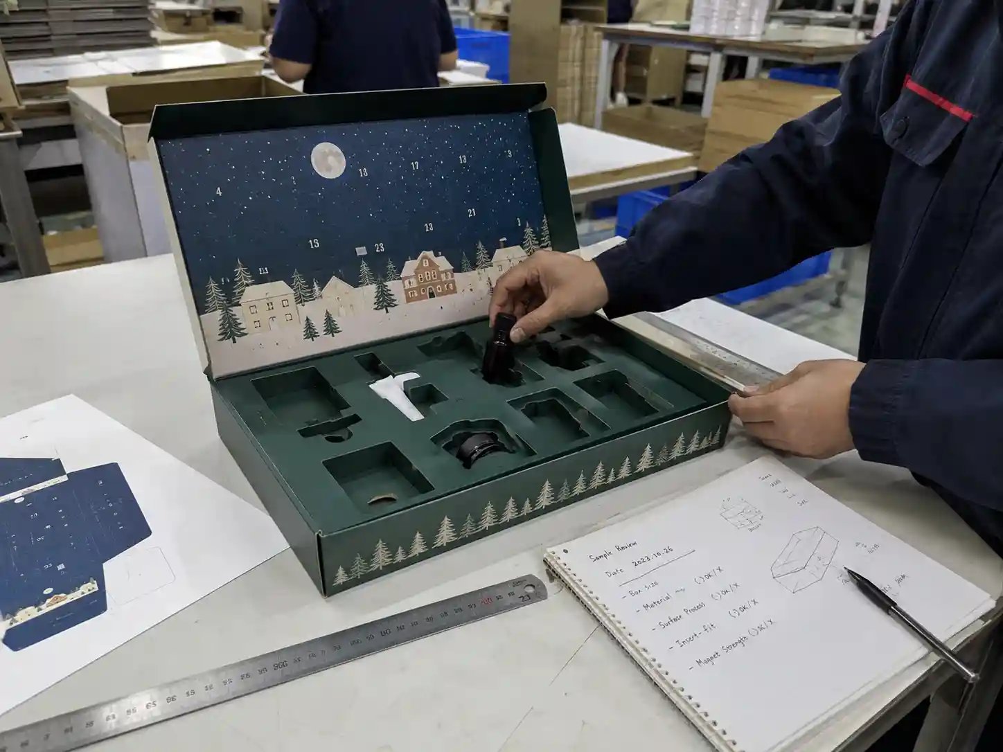 Worker checking insert fit for custom advent calendar box sample before production