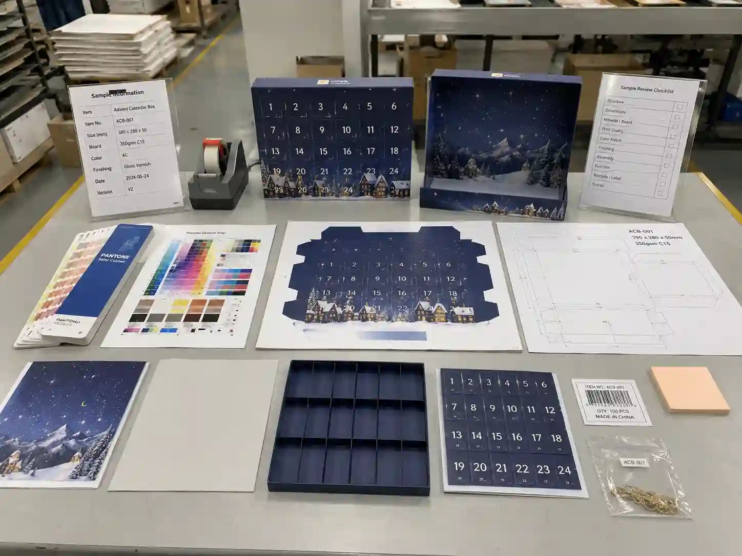 Printing proof table with Pantone cards and CMYK sheets for window advent calendar boxes