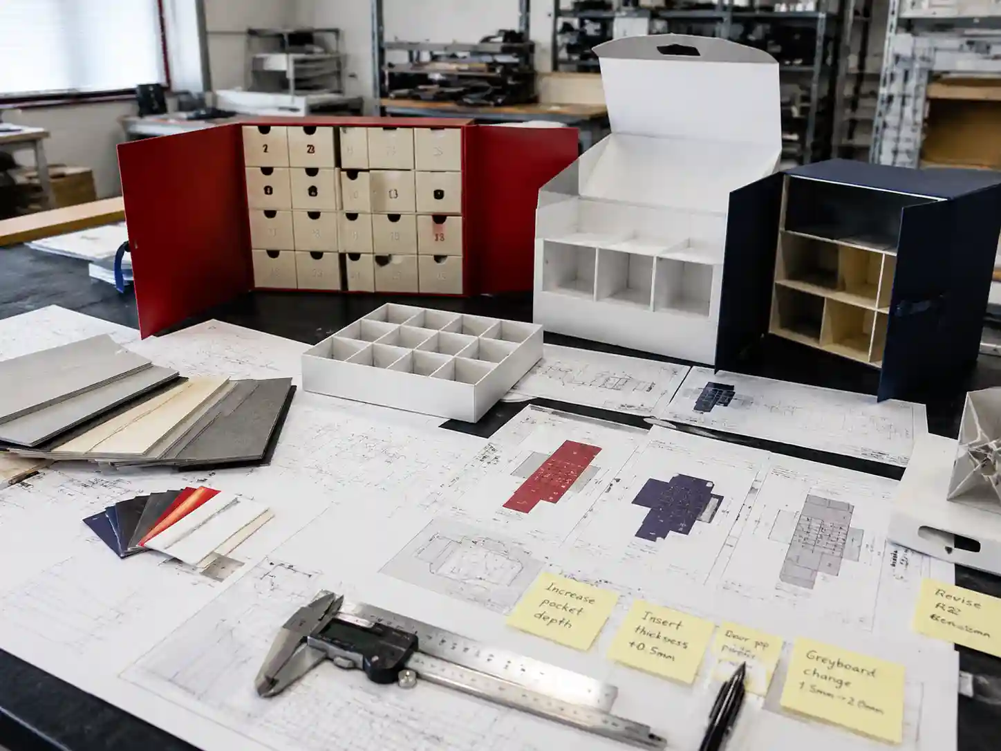 Packaging engineers checking advent calendar box sample revisions, drawings, inserts, and production specifications.