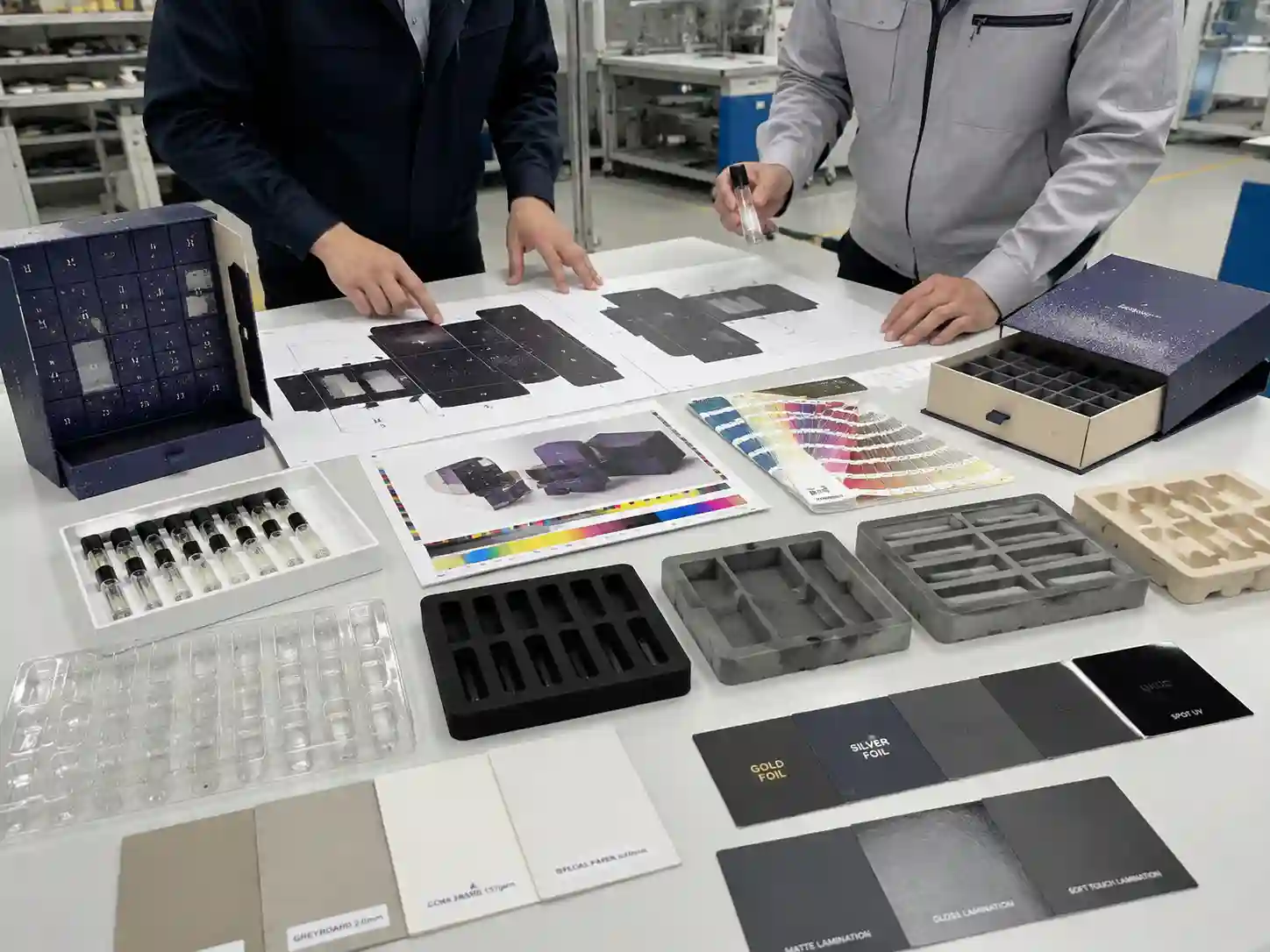 Packaging engineers reviewing perfume sample advent calendar box printing materials, inserts, dielines, and finishing options