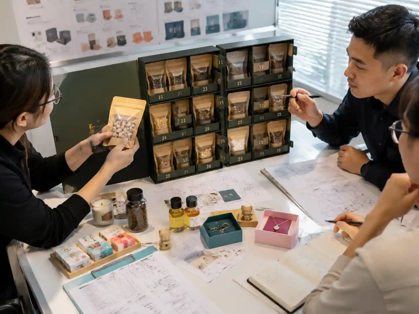 Packaging specialists reviewing pet treat pouch fit and compartment design in an advent calendar prototype