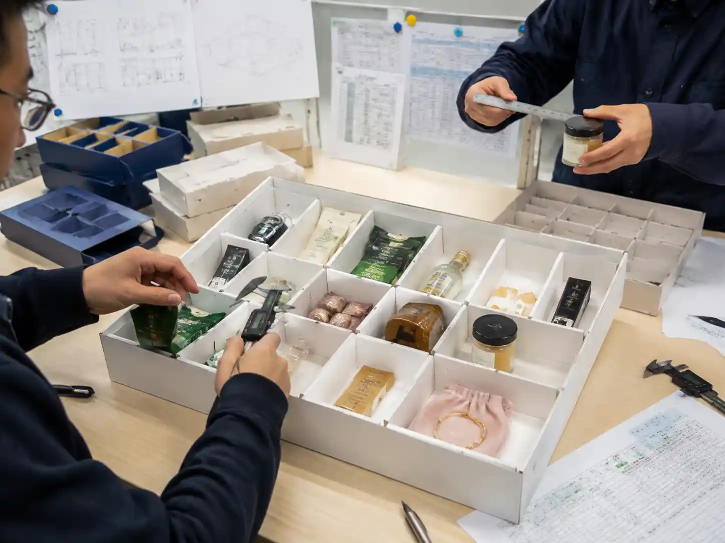 Packaging engineers testing product fit and primary packaging protection in gift calendar inserts